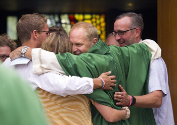 Priest hugging parishioners