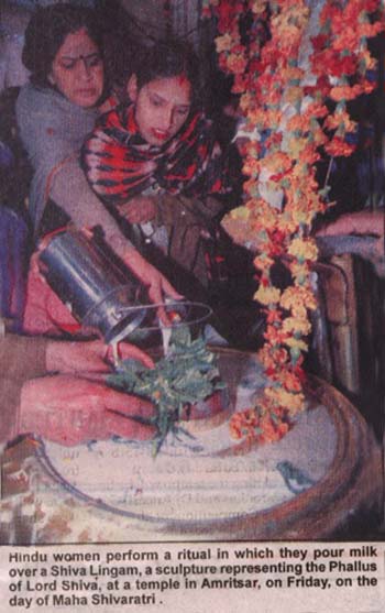 A woman pouring milk on a Shiva Linga