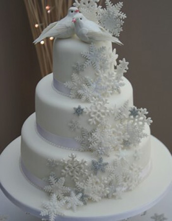 A wedding cake with two dove figures on top