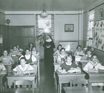 A black and white photograph of a nun taught school room in the past