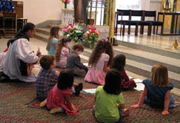 Children at the Children of Hope chapel sitting on the floor casually