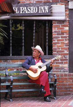 A man playing a guitar on Olvera Street