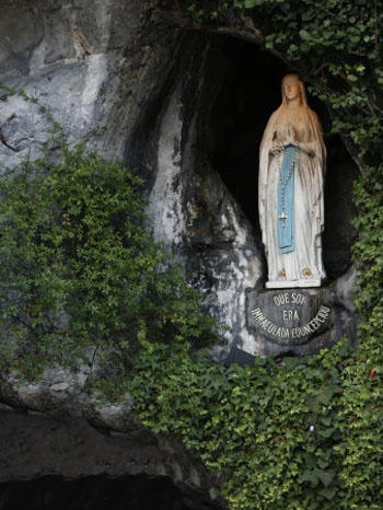 A statue of Our Lady of Lourdes in the Lourdes grotto