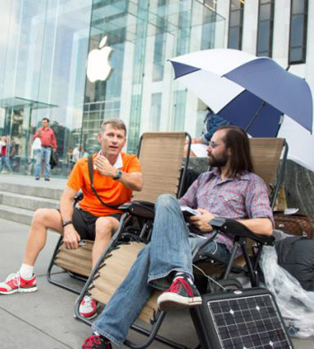 two slovenly  man-boys in shorts and jeans outside an apple store