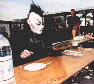 A gothic punk seated in a fast food restaurant