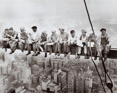 Construction workers lunching high up on a skyscraper beam