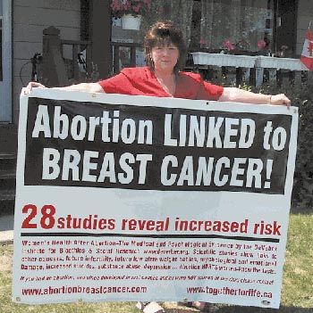 A woman holding a breast cancer abortion link sign
