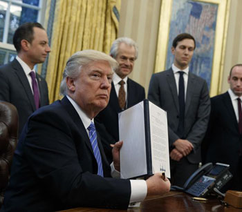 President Trump displaying his signature on the ban againt international abortion