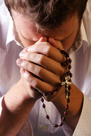 Young man praying the Rosary