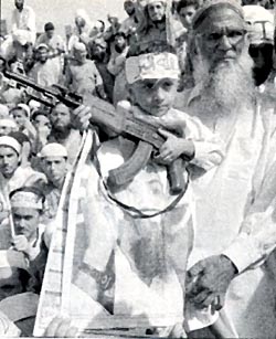 A muslim boy wields a rifle