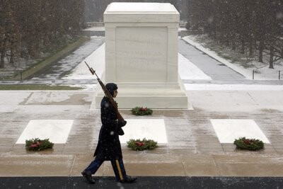 A guard marching past Arlington cemetery at Christmas