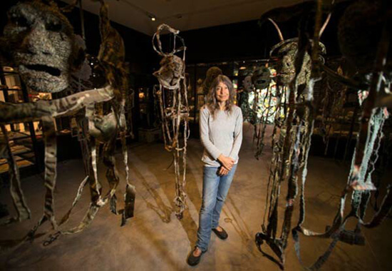 Fiona Hall surrounded by hideous sculptures of her own creation