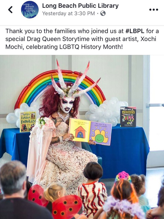 Xochi Mochi in a drag demon outfit reading to children at the Michelle Obama library