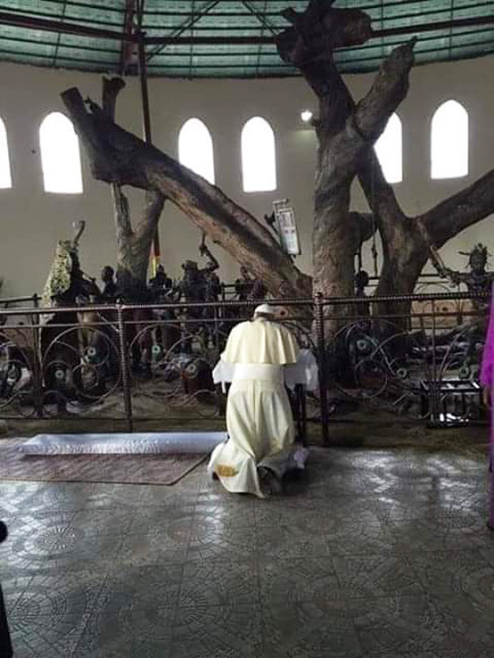 Francis kneels before a tree