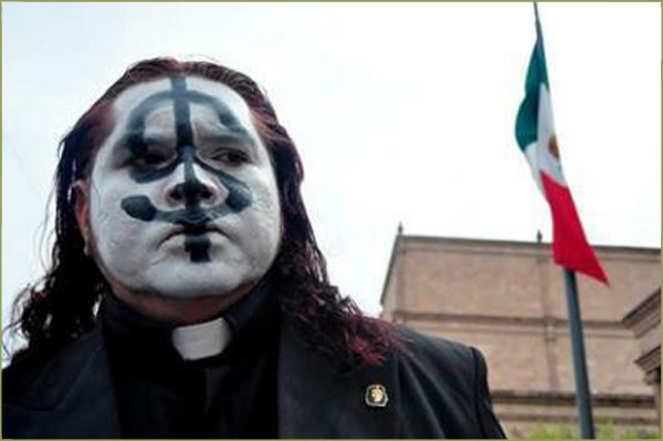 Fr. Adolfo Huerta Aleman with a dollar sign painted on his face