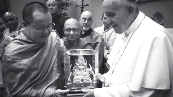 Pope Francis smiling as he accepts a statue of Buddha from a group of Buddhist monks
