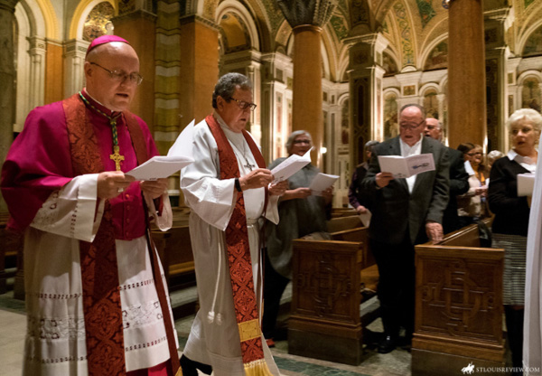 Bishop James Massa praying alongside Lutheran Donald McCoid in St Louis Cathedral