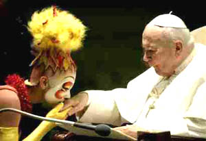 A clown kissing the hand of the Pope