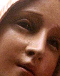 A closeup photograph of a weeping statue of Our Lady