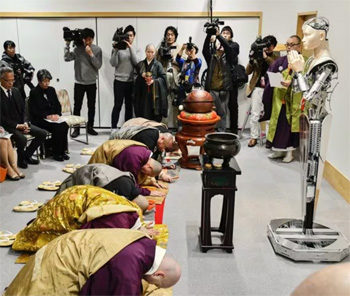 Buddhist monks bowing to a robot teacher