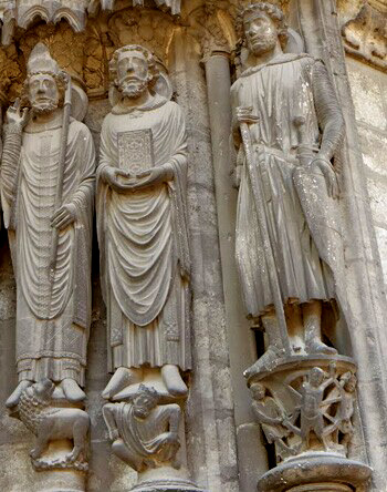 carved stone statues of St Denis and St. Georges on the facade of a Cathedral