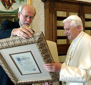 Benedict receives a framed Lutheran prayer from a protestant