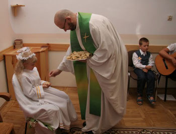 Neocatechumenal receiving first communion seated and in the hand